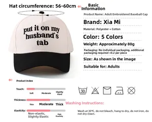 Detail of pink and black baseball cap with embroidered 'put it on my husband's tab' text