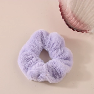 Dettaglio dell'elastico per capelli in finta pelliccia viola chiaro con morbida trama soffice