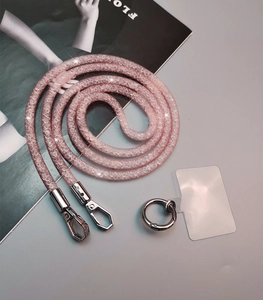 Detailed view of pink rhinestone phone lanyard with silver metal clasp and clear connector pad