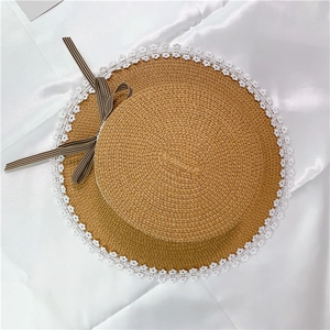 Detail of flat top straw hat with floral lace trim and brown checkered bow tie