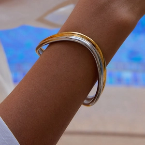 Dettaglio di un bracciale a onde bicolore in oro 18 carati e argento in acciaio