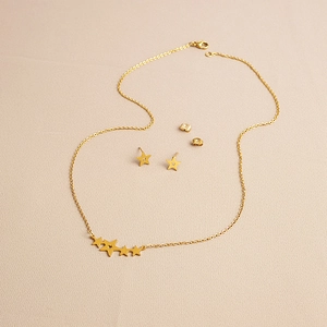 Detailed view of the gold-plated stainless steel star necklace and stud earrings set