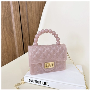 Detailed macro of pink glitter PVC bag featuring pearl handle and gold twist lock
