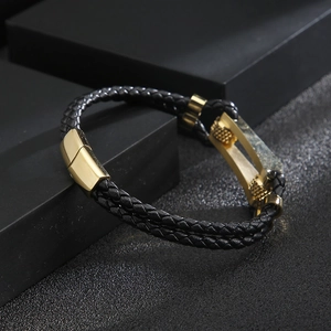 Detail of black braided leather men's bracelet with gold magnetic metal clasp