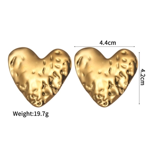 Detail view of large 18K gold-plated heart earrings with hammered lava texture finish