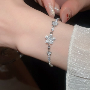 Detail of silver flower and star zircon bracelet on wrist with pull-chain design