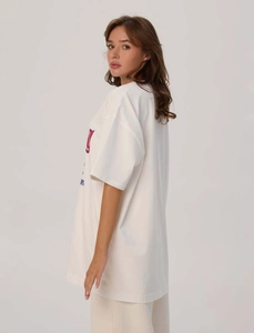 Dettaglio della maglietta oversize in cotone bianco che mostra profilo e stampa vintage