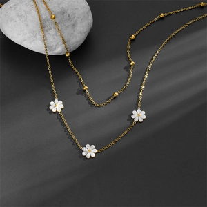 Double-layered gold titanium steel necklace featuring white daisy charms and gold beads