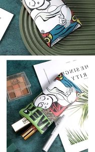 Detailed view of artistic canvas pouch with portrait print organizing various makeup items