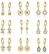 Macro detail of nine-pair gold earring set with leaf, star, and gemstone charms