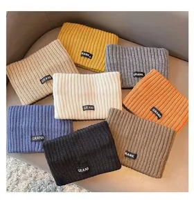 Collection of colorful ribbed knit headbands with GRANK labels displayed on a sofa