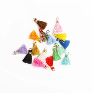 Macro shot of colorful mini tassel pendants with gold metal caps for DIY jewelry crafts