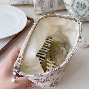 Detailed interior of blue floral canvas makeup bag showing large storage capacity