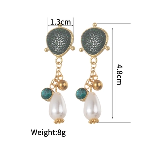 Minimalist gold teardrop earrings featuring green crystals and white pearl pendants