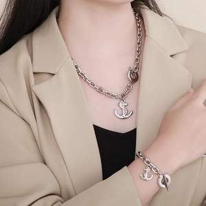 Detail of silver anchor necklace and bracelet set with OT toggle clasp on model