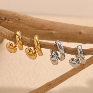 Ear cuff a spirale a doppio strato placcati in oro 18K e argento su un ramo di legno