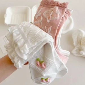 Detail von Babysocken mit feiner Kirschstickerei und gerüschten Spitzenbündchen