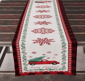Christmas table runner with red truck and snowflake patterns on a wooden dining table