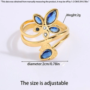Detail of adjustable golden titanium steel ring with butterfly and blue gemstone accents