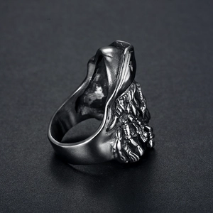 Macro detail of gothic viking skull ring featuring oxidized finish and embossed monster relief