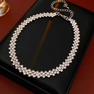 Elegant three-row rhinestone choker necklace with adjustable chain on a leather display