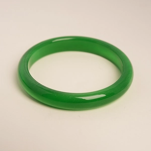 Detail of green cat-eye stone bangle with polished round design and rich oily luster