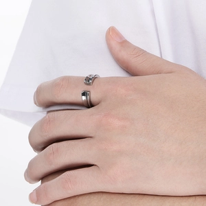 Detail of silver stainless steel open ring with V-groove design on a model finger