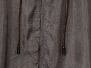 Macro shot of dark taupe woven fabric with premium metal zipper and woven drawstrings