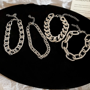 Set of four silver metal chain bracelets with various links and adjustable lobster clasps