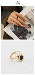 Detail of Roman numeral rotating ring with gold finish and small sparkling crystal stone