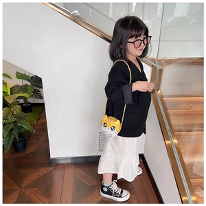 Fillette portant un sac à bandoulière chat jaune avec chaîne dorée dans l'escalier