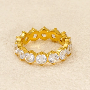 Detail of 18k gold plated eternity ring featuring classic prong set cubic zirconia stones