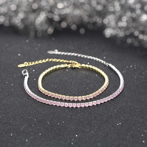 Macro shot of silver and gold tennis bracelets featuring round pink zircon stones