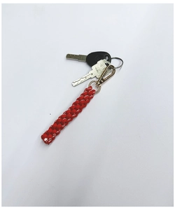 Detail of red and white hand-woven rope keychain with gold metallic spring clasp and keys