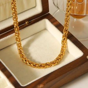 Detail of 18K gold plated stainless steel wheat chain inside a luxury wooden jewelry box