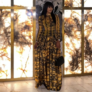 Detail of high neck long sleeve maxi dress in yellow and black tie-dye print with pleated hem