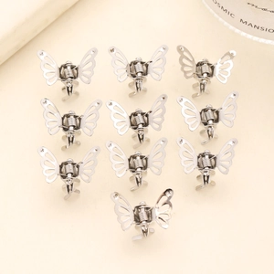 Detailed top view of 10 mini silver metal butterfly hair clips arranged on beige background