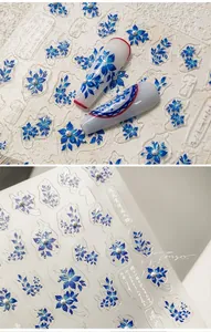 Detail of blue floral nail art stickers with embossed textures and pearl accents