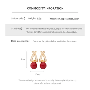Detail showing vintage gold-plated earrings with red resin bead and size dimensions
