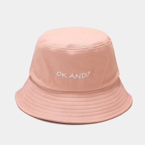 Detailed close-up of light pink cotton fisherman hat with white OK AND? embroidery