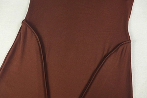 Close-up of coffee brown knit fabric detail with refined stitching on the jumpsuit
