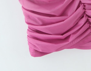 Dettaglio del tessuto a rete rosa con intricate texture pieghettate e morbide arricciature