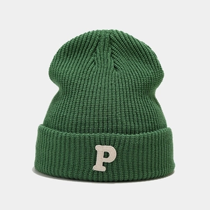 Green cuffed knit beanie with white P letter embroidery on minimalist background