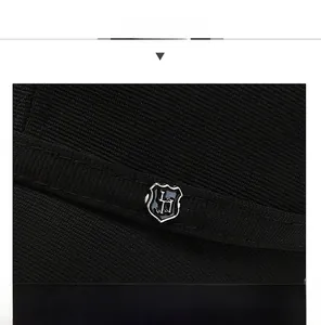 Dettaglio del tessuto della calotta nera e del logo metallico a scudo con bordo argento