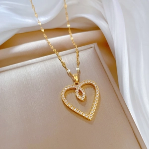 Elegant gold heart pendant necklace with shimmering crystals on a champagne silk background