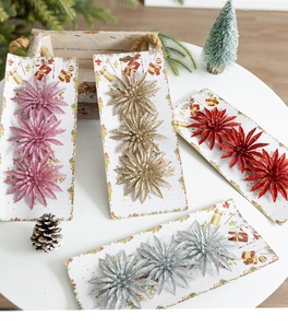 Glittery artificial Christmas flowers displayed with pine cones and holiday ornaments
