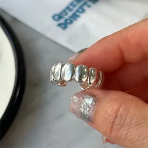 Close-up of S925 sterling silver chunky oval ring with textured wave design on finger
