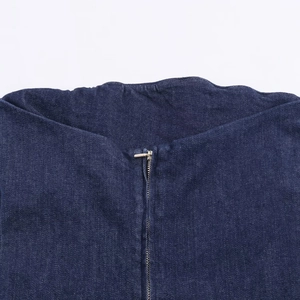 Détail de l'encolure et de la fermeture éclair argentée sur cette robe en jean bleu foncé