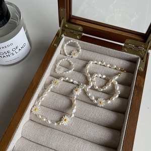 Close-up of freshwater pearl daisy necklace and ring set in a wooden velvet jewelry box
