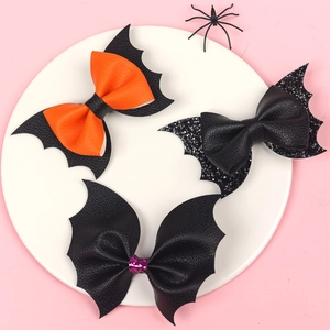 Detailed view of Halloween bat wing bow hair clips in orange, black glitter and leather